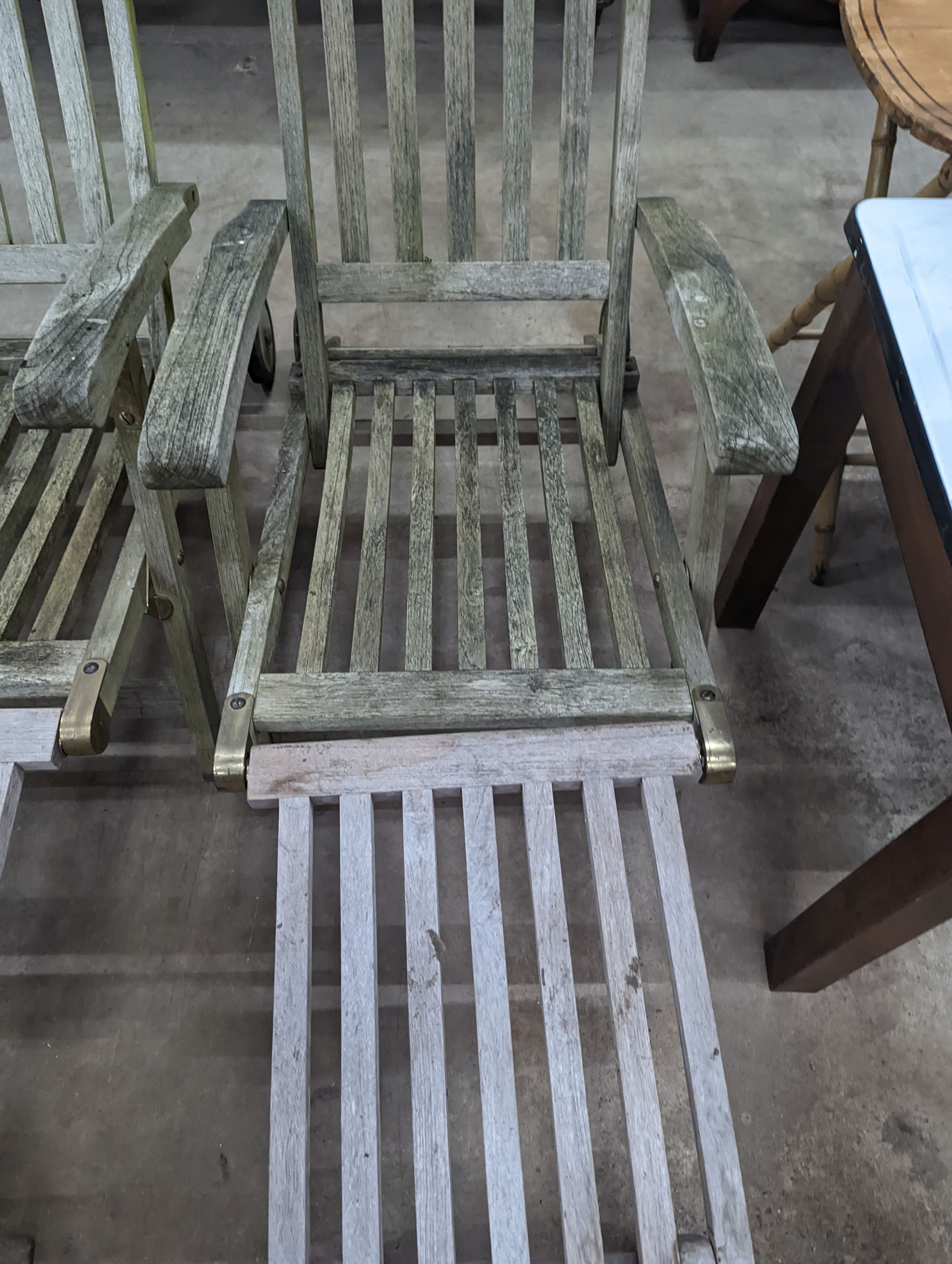 A pair of slatted weathered teak garden steamer chairs, width 59cm, height 97cm